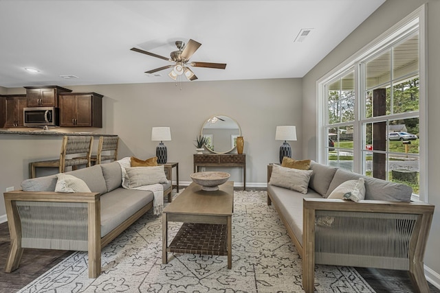 living room with ceiling fan and light wood-type flooring