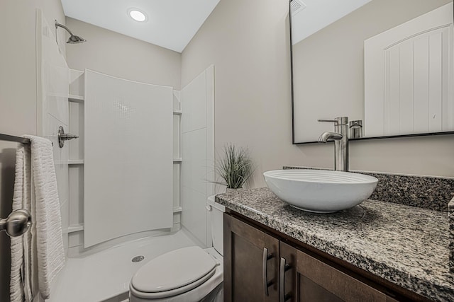 bathroom featuring vanity, toilet, and a shower