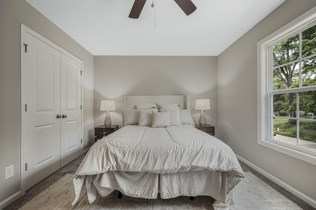 carpeted bedroom featuring ceiling fan and a closet