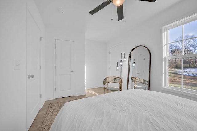 bedroom featuring multiple windows, ceiling fan, and light wood-type flooring