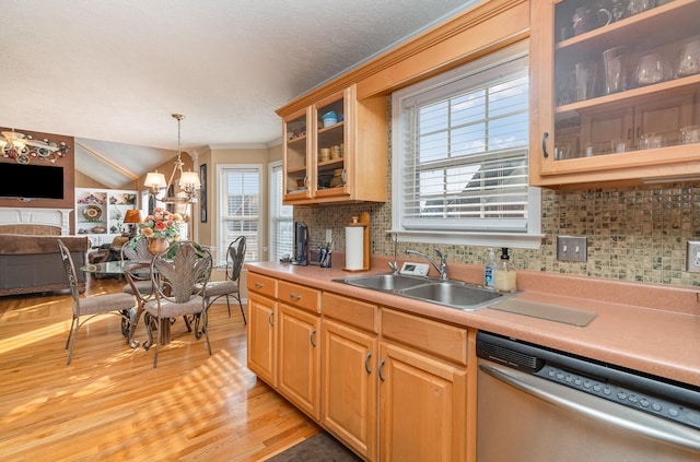 kitchen featuring pendant lighting, sink, dishwasher, tasteful backsplash, and light hardwood / wood-style floors