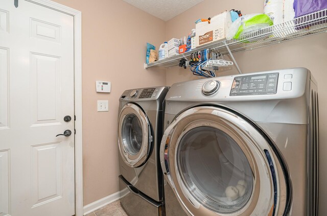 laundry room featuring washer and clothes dryer and light tile patterned floors