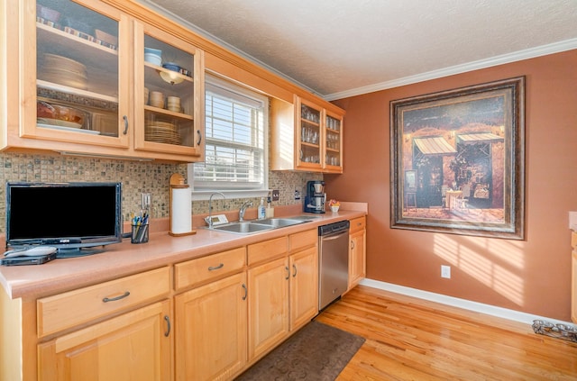 kitchen with dishwasher, sink, backsplash, crown molding, and light wood-type flooring