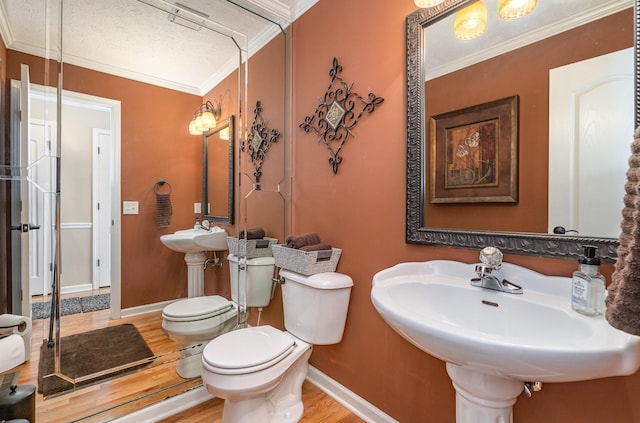 bathroom featuring ornamental molding, wood-type flooring, sink, and toilet