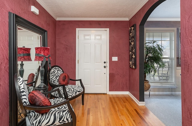 foyer featuring crown molding, wood-type flooring, and a textured ceiling