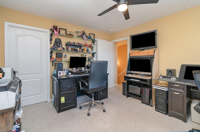 carpeted office with a textured ceiling and ceiling fan