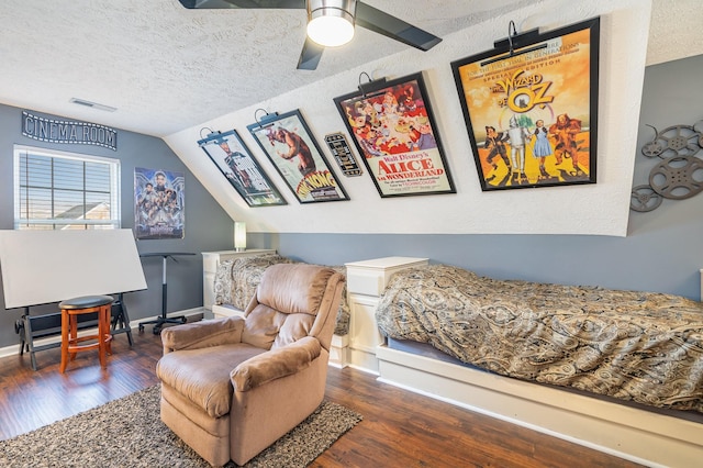 bedroom with dark hardwood / wood-style flooring, vaulted ceiling, and a textured ceiling