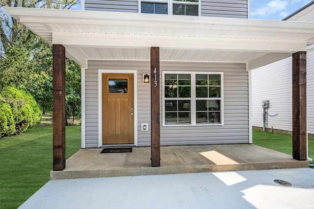 property entrance featuring a yard and a porch