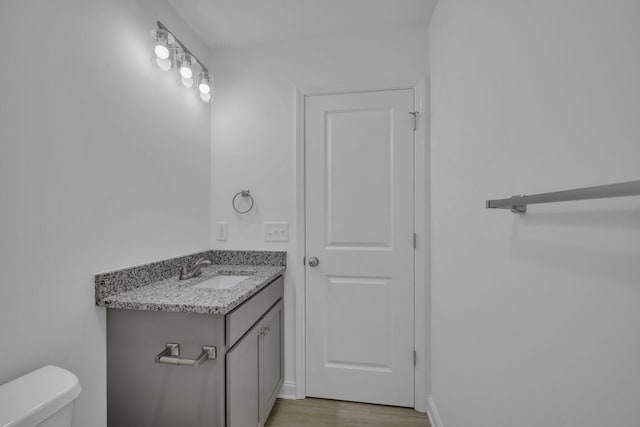 bathroom with vanity, hardwood / wood-style flooring, and toilet