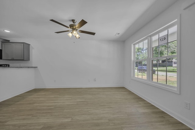 unfurnished living room featuring light hardwood / wood-style flooring and ceiling fan