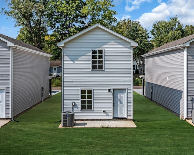 rear view of house featuring a patio, a lawn, and central air condition unit