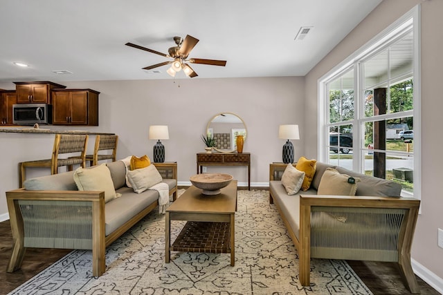 living room with light hardwood / wood-style flooring and ceiling fan