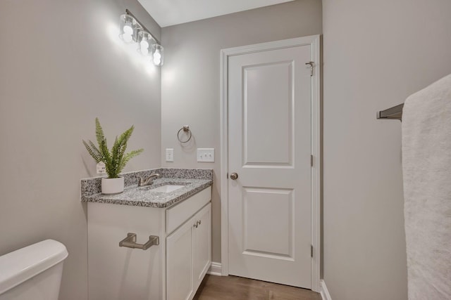 bathroom with vanity, hardwood / wood-style floors, and toilet