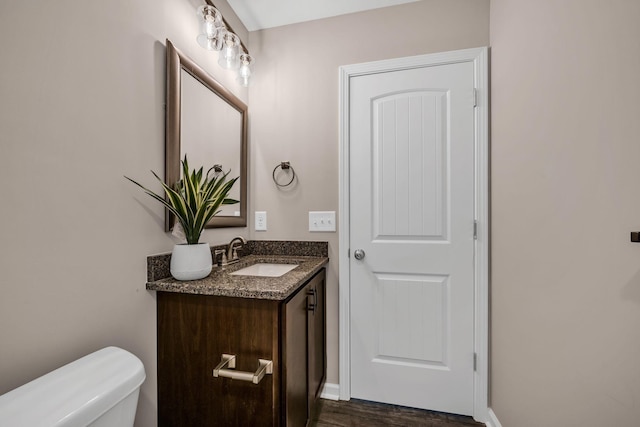 bathroom featuring vanity, wood-type flooring, and toilet