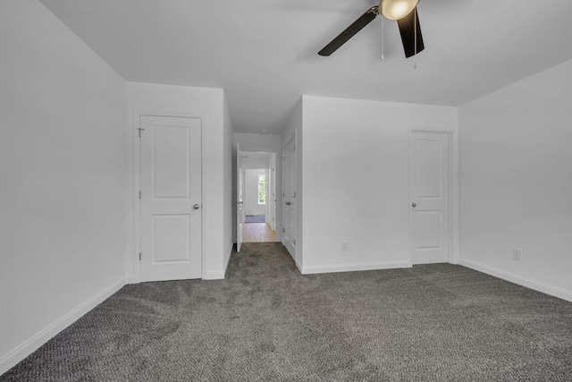 unfurnished bedroom featuring dark colored carpet and ceiling fan