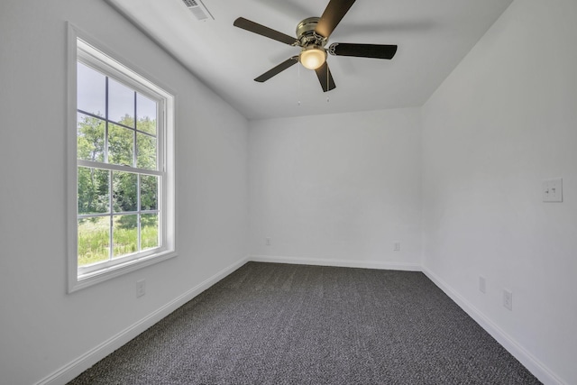 empty room featuring ceiling fan and dark carpet