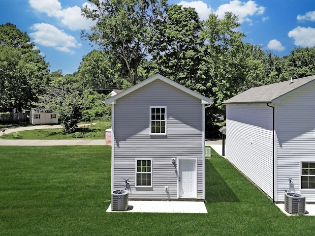 back of house with central AC and a yard