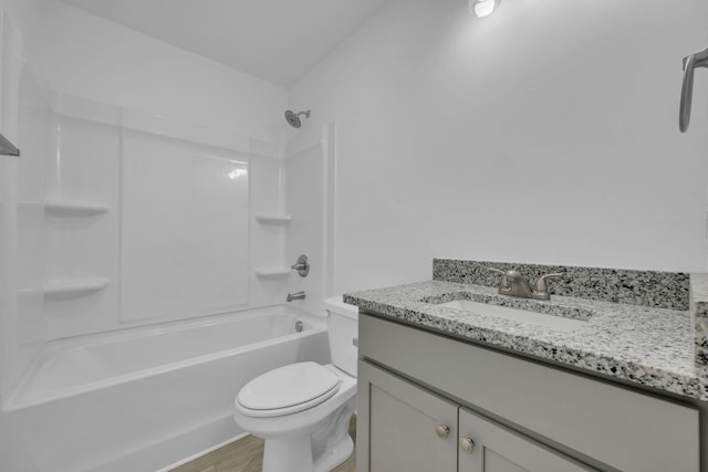 full bathroom featuring hardwood / wood-style flooring, vanity, tub / shower combination, and toilet