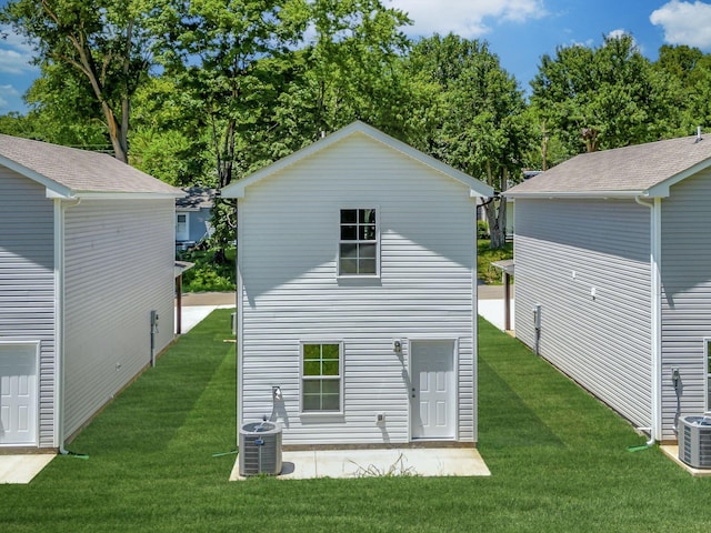 rear view of property with a yard and central AC