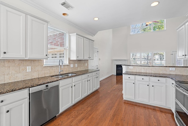 kitchen featuring stainless steel appliances, sink, dark stone counters, and white cabinets