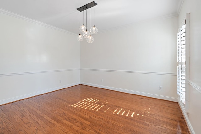 empty room with an inviting chandelier, crown molding, and wood-type flooring