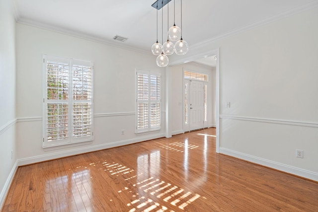 unfurnished room featuring ornamental molding, light hardwood / wood-style flooring, and a wealth of natural light