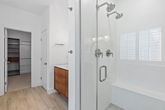 bathroom featuring vanity, wood-type flooring, and walk in shower