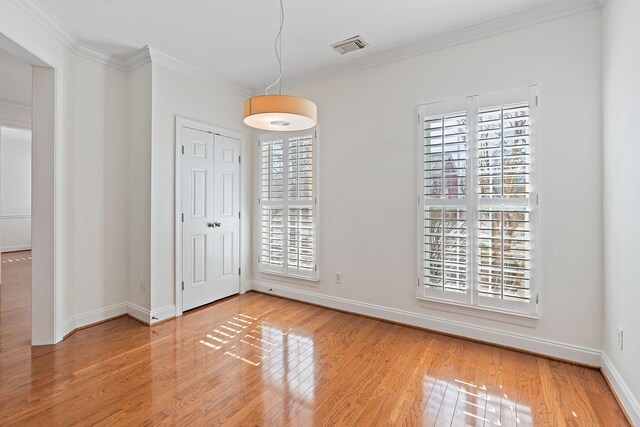 spare room with crown molding and wood-type flooring