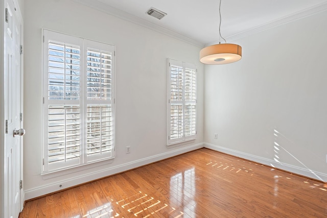 empty room with crown molding and light wood-type flooring