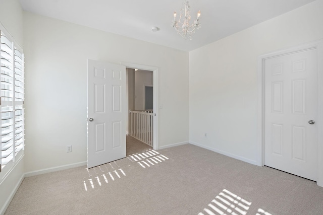 unfurnished bedroom featuring multiple windows, light colored carpet, and a notable chandelier