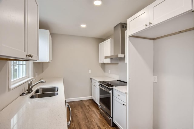 kitchen featuring dark hardwood / wood-style floors, sink, white cabinets, wall chimney range hood, and stainless steel electric range