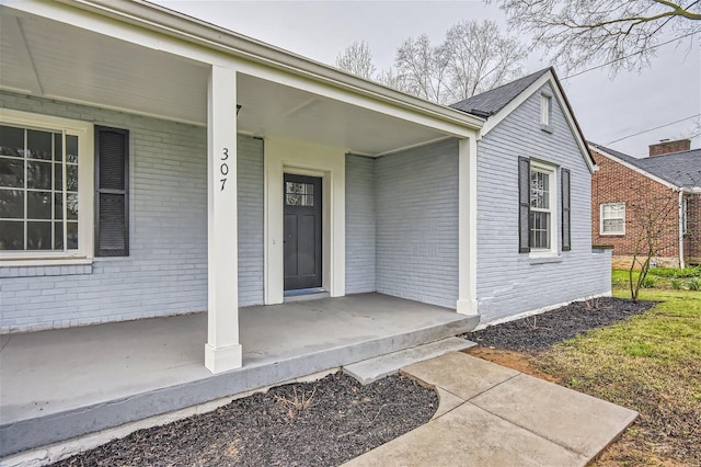 view of exterior entry featuring covered porch