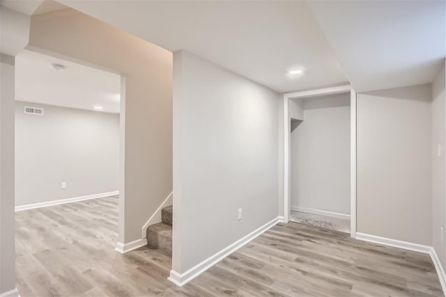 basement with light hardwood / wood-style flooring