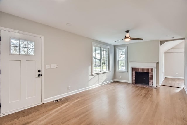 unfurnished living room with a fireplace, light hardwood / wood-style flooring, and ceiling fan