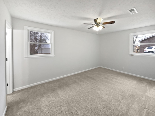 carpeted spare room with ceiling fan and a textured ceiling