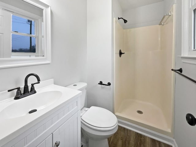 bathroom with vanity, hardwood / wood-style floors, toilet, and a shower