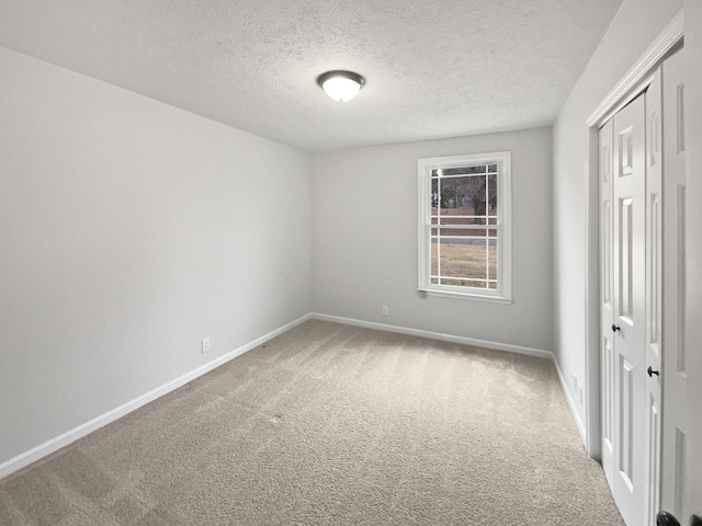 carpeted spare room with a textured ceiling