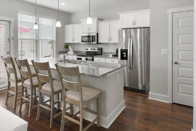 kitchen featuring hanging light fixtures, white cabinetry, appliances with stainless steel finishes, and sink