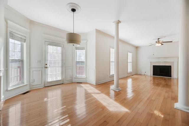 unfurnished living room featuring crown molding, ceiling fan, light hardwood / wood-style flooring, and ornate columns