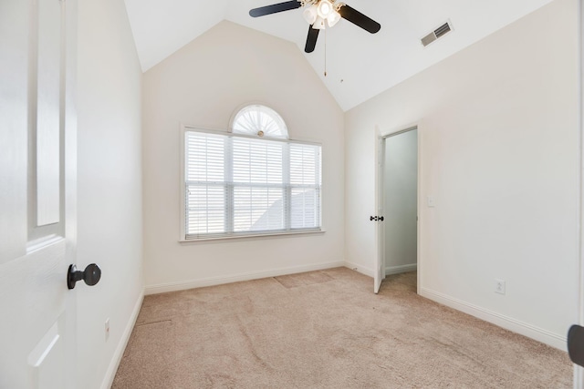 empty room with ceiling fan, light colored carpet, and vaulted ceiling