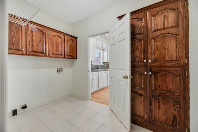 laundry area with washer hookup, sink, light tile patterned floors, and cabinets