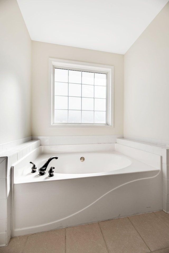 bathroom with a bathtub, plenty of natural light, and tile patterned floors