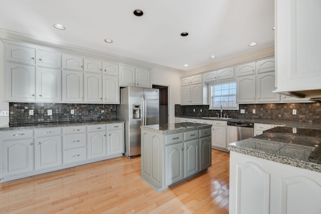 kitchen featuring appliances with stainless steel finishes, sink, white cabinets, and light hardwood / wood-style flooring