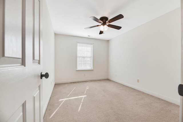 spare room featuring light colored carpet and ceiling fan