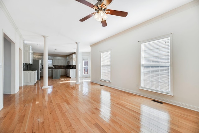 unfurnished living room featuring ornamental molding, light hardwood / wood-style flooring, and ornate columns