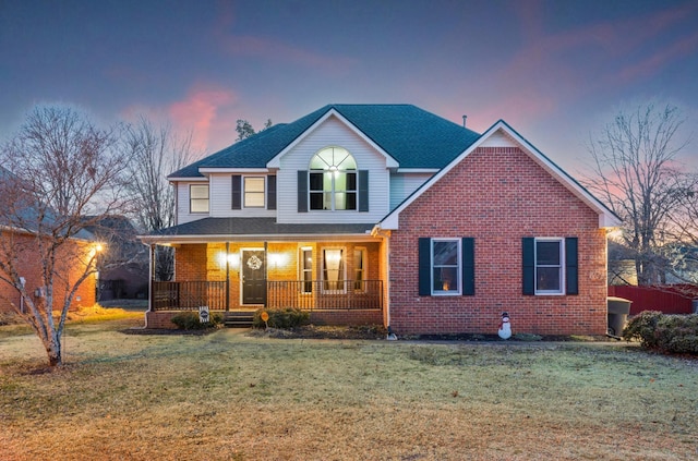 view of front property featuring covered porch and a lawn