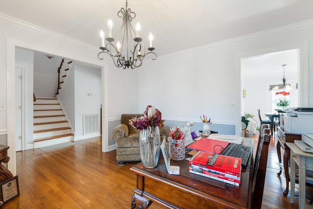 dining area featuring hardwood / wood-style flooring, ornamental molding, and an inviting chandelier