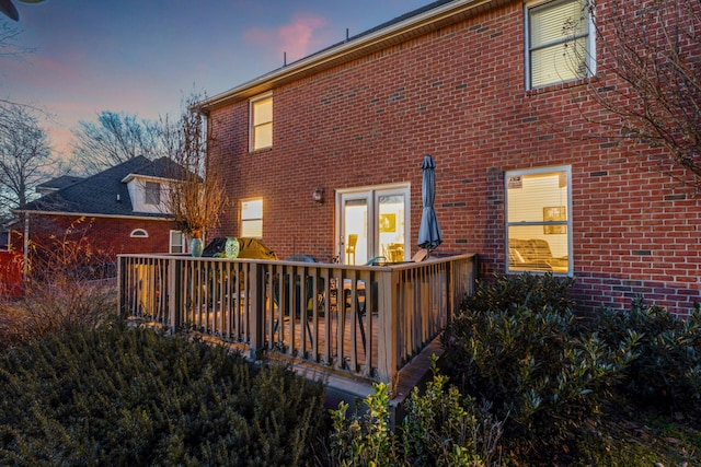 back house at dusk with a deck