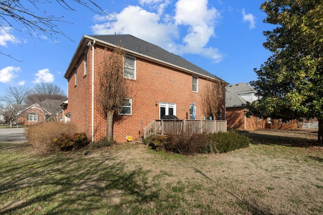 view of property exterior with a yard and a deck