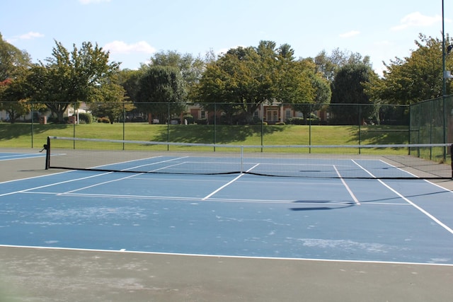 view of tennis court with a yard